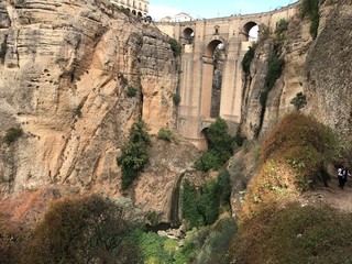 Bridge in Ronda famous and romantic Andalusia Spain. Photo from the viewing point under the bridge.  You can see the rocky cliffs of both sides of the bridge