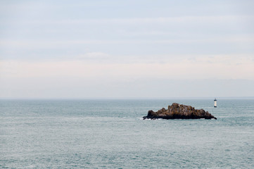 France. Bretagne. Ilot et phare sur la cote bretonne. Island and lighthouse on the Brittany coast.