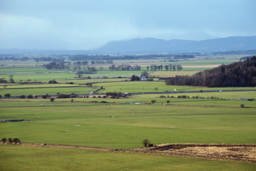 Fototapeta na wymiar Scottish winter landscape with green fields and mountains. Stirling, Scotland