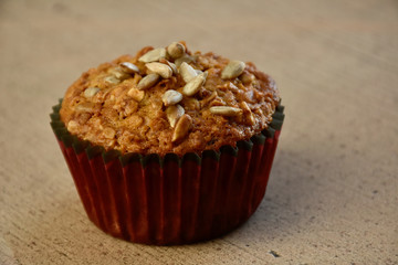 Healthy muffin with sunflower seeds oatmeal and raisins on wooden table