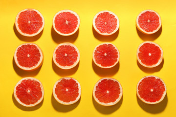 Flat lay composition with tasty ripe grapefruit slices on yellow background