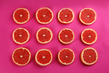 Flat lay composition with tasty ripe grapefruit slices on magenta background