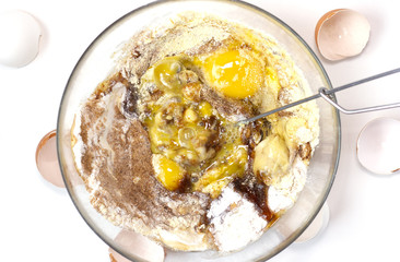 CooCorn and rice flour, coconut sugar, four eggs in the transparent plate. Making a cake. Mixing the dough. White background. Copy space. Place for text and design. Top view. Flat lay. Gluten-free rec