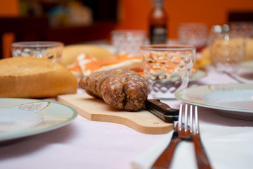 salami with knife on cutter board on laid table