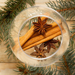 spices anise cinnamon in a transparent glass with a branch of spruce, winter holiday theme