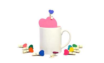 Valentine's day. paper heart shape in white coffee cup with small clip heart shape. isolated on white