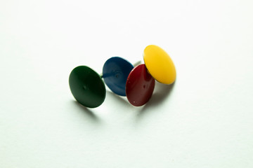 Push pins on a white background. Colored and silver buttons. Many and one. Blue, Yellow, Red.
