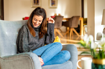 Relaxed woman sitting in the armchair at home