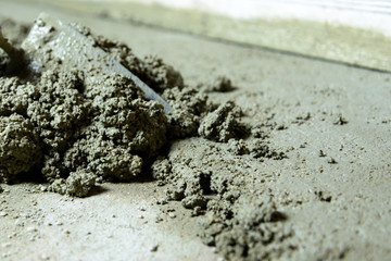 Use of prefabricated concrete for home renovation, base concrete repair. Close-up of partially smoothed, wet concrete.