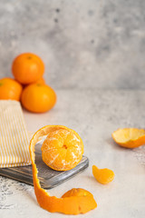 Fresh mandarin oranges fruit and peeled segments on cutting board. Tangerines background.