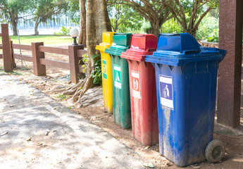 Trash can color yellow, green, red, blue on the side of the road.