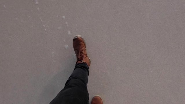 Top Down view of walking on a sand beach at the lofoten islands with brown shoes