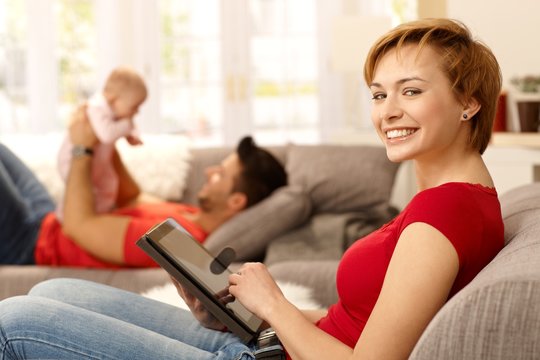 Happy woman using tablet at home