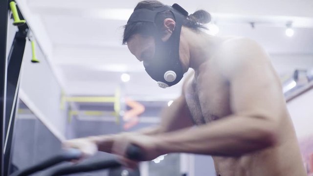man in a training mask, trains on a bike
