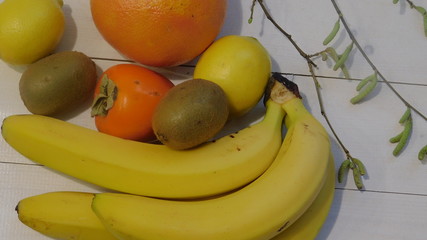Tropical fruits of various sizes on a white wooden table background 