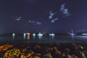 Dive boats under a starry and cloudy night