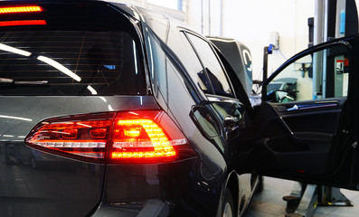 Modern car at a service station.  In the frame, the rear of the car, close-up taillight, taillight...