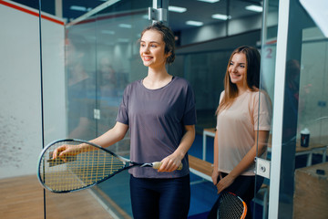 Two female squash players poses in locker room
