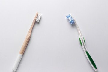 Zero waste concept, Eco wooden toothbrush vs plastic toothbrush on white background: Reduce, Reuse and Recycle concept. Flat lay, View from above