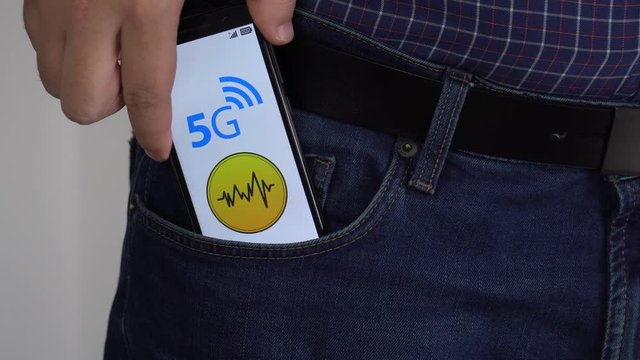 Person putting a smartphone in his pocket covered with foil