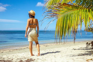A young woman with a hat on West End beach on Roatan Island. Honduras