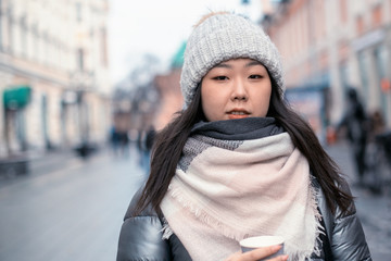 Beautiful young Korean girl on a walk around the city on a winter day.