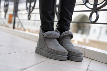 gray female stylish low uggs with fashionable stitching on legs indoors