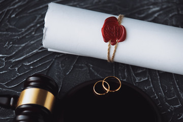 Two broken golden wedding rings divorce decree document.
