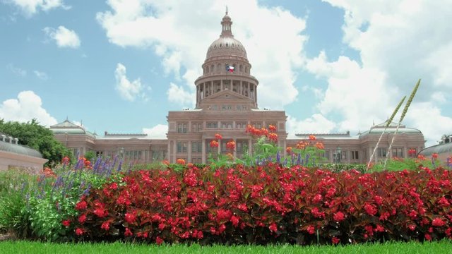 Austin, Texas State Capitol facade with beautiful Indian paintbrush flowers moving in the breeze on a sunny summer day