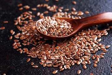 Uncooked linseed in wooden spoon, rustic style. Healthy linseed