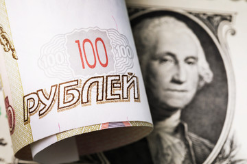 Russian one hundred rubles against the background of the dollar. Currency devaluation concept