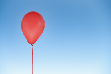 Red balloon for birthday and celebrations isolated at blue sky