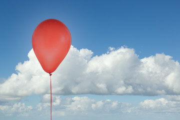Red balloon isolated at blue sky with clouds