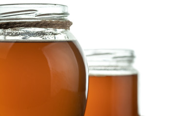 Round glass jars with freshly prepared ghee butter. Isolated on a white background.