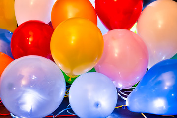 Colorful balloons illuminated with LED against dark background