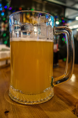 mug of cold fresh beer on a table in a pub