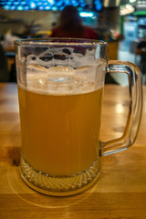 mug of cold fresh beer on a table in a pub