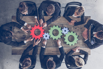 Business people joining gears