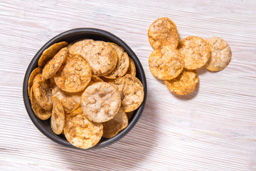 Top view pile of organic, crispy, baked, whole grain rice chips with spices. Gluten free healthy...