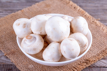 Fresh champignons in a white plate