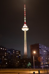 Obraz premium Vilnius TV Tower, Lithuania colored with white light, night, with soviet buildings, vertical