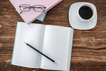 Pencil and an open notebook on white table. Bird eye view, mock-up concept.