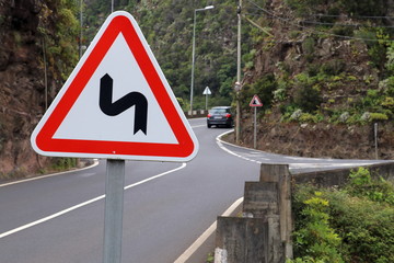 Winding road traffic sign on the mountain background