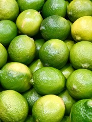 Large stack of limes on display at the market