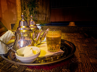 Fresh mint tea in typical tea metal pots and jars in a restaurant, Marrakesh, Morocco. It is a...