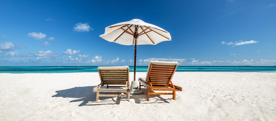 Beautiful tropical scenery, two sun beds, loungers, umbrella under palm tree. White sand, sea view...