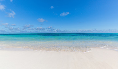 Fototapeta na wymiar Idyllic beach view. Peaceful tropical landscape. Blue sea and sky over white sand
