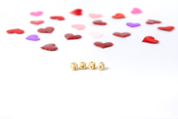 Love on wooden cubes with shadow on a white background of multi-colored hearts