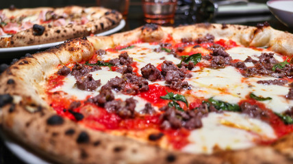 wood oven classic pizza of minced meat with mozzarella cheese and tomato sauce ready to eat