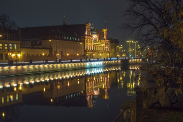 Night view of Wroclaw streets. Reflection of buildings in the Odra River. Poland